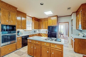 Una cocina con armarios de madera, electrodomésticos de acero inoxidable y una isla grande.