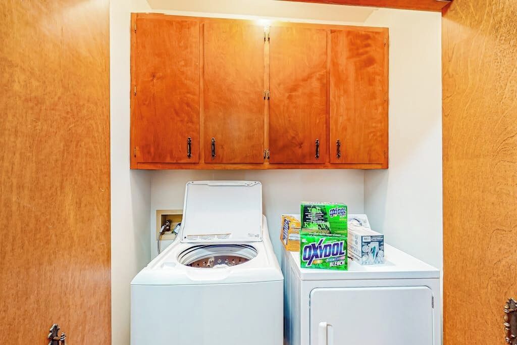 A laundry area with a washing machine, dryer, and detergent boxes.