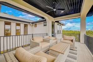 A covered outdoor seating area with wicker furniture and a ceiling fan. - Exquisite Dog-friendly Home With Balcony, Enclosed Yard, Central AC, & W/D (Leander)