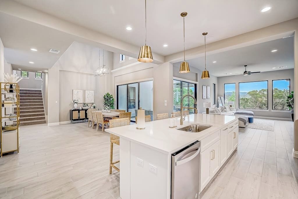 Una cocina amplia con una isla grande, iluminación colgante y vistas al exterior.