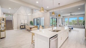 A spacious kitchen with a large island, pendant lighting, and a view of the outdoors. - Exquisite Dog-friendly Home With Balcony, Enclosed Yard, Central AC, & W/D (Leander)