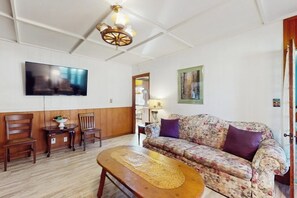 A living room with a sofa, chairs, a coffee table, a TV, and a ceiling fan. - Charming, Dog-friendly Home With Patio, Grill, & Parking - Close to Town (Fredericksburg)