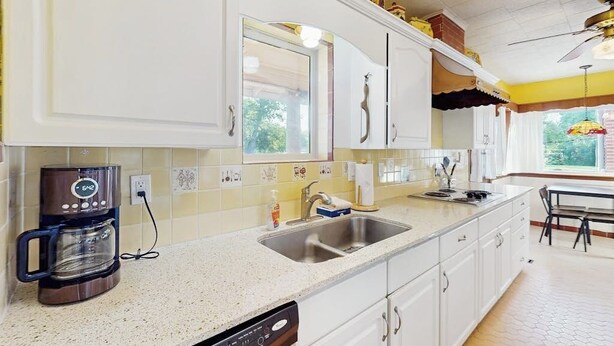 A kitchen with white cabinets, a coffee maker, a sink, and a window. - Charming, Dog-friendly Home With Patio, Grill, & Parking - Close to Town (Fredericksburg)