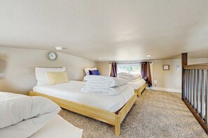 A hotel room with two beds, a clock on the wall, and a window with curtains. - Modern Tiny Home With Loft, Kitchen, Cozy Patio and Shared Pools, Great Location (Fredericksburg)