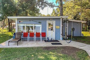 A small building with a door, a bench, and a swing set. - Charming Dog-friendly Lakefront Home With Lake View, Dock, & Washer/dryer (Kingsland)