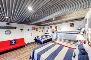 A compact room with a bunk bed, a red bench, and a small kitchenette. - Charming Dog-friendly Lakefront Home With Lake View, Dock, & Washer/dryer (Kingsland)