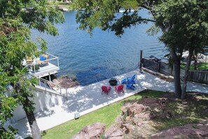A backyard with a pool, outdoor seating, and a deck overlooking the water. - Lakefront Home With Wifi, Entertainment, Dock & Lake Views - Dogs OK (Burnet)