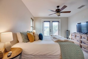 A bedroom with a bed, a TV, a ceiling fan, a dresser, and a window. - Lakefront Home With Wifi, Entertainment, Dock & Lake Views - Dogs OK (Burnet)