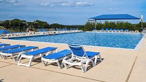 A swimming pool with blue lounge chairs and a covered area. - 2-story Townhouse With Balcony, Outdoor Pool, Tennis, Grill, Basketball, & AC (Leander)