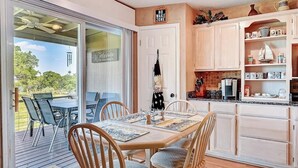 Uma sala de jantar com mesa e cadeiras, uma cozinha com armários e bancada, e uma placa indicando 'No Wake Zone'.