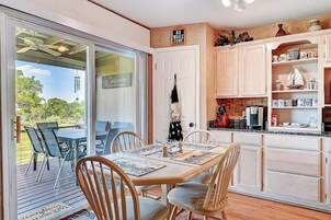 Un comedor con mesa y sillas, una cocina con armarios y una encimera, y un letrero que indica 'No Wake Zone'.