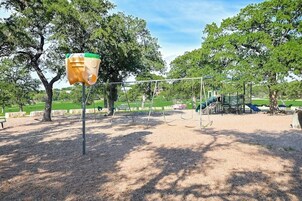 Un parque infantil con columpios, un tobogán y una estructura para escalar.