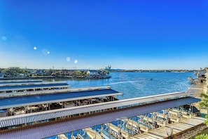 Ein Ufergrundstück mit mehreren Anlegestellen, einer großen, offenen Terrasse und Blick aufs Wasser.