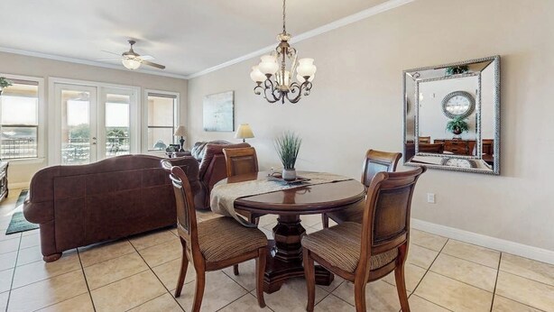 A dining area with a chandelier, a round table, and chairs. - Waterfront Condo With Furnished Balcony, Central AC, & Washer/dryer (Horseshoe Bay)