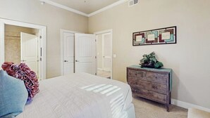A bedroom with a bed, a dresser, and a ceiling fan. - Waterfront Condo With Furnished Balcony, Central AC, & Washer/dryer (Horseshoe Bay)
