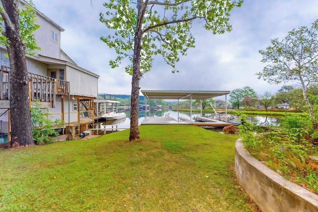 A house with a deck, a covered outdoor area, and a body of water.