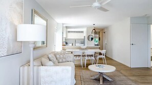 Ein modernes Wohnzimmer mit einer Couch, einem Couchtisch und einem Essbereich mit Stühlen.