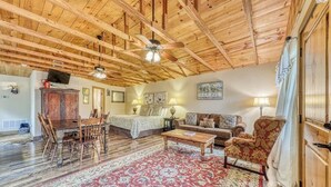 A spacious living room with a wooden ceiling, a dining area, a sofa, a coffee table, and a patterned rug. - Three Lovely Homes, Group- Family-friendly, Near Downtown, 2 Dogs OK (Fredericksburg)