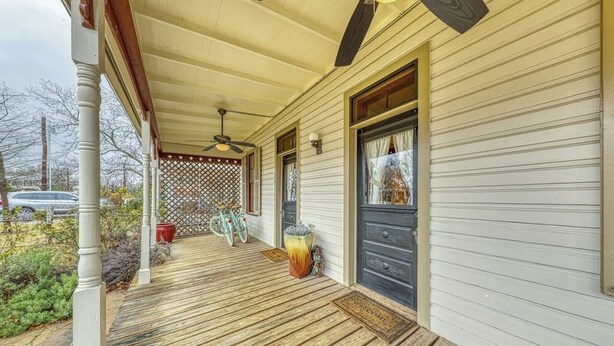 A covered porch with a ceiling fan, wooden floor, and a door with a window. - Three Lovely Homes, Group- Family-friendly, Near Downtown, 2 Dogs OK (Fredericksburg)