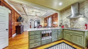 A kitchen with wooden cabinets, a large island, and a stainless steel range hood.