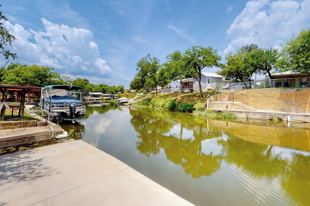 Un canal, avec un camion garé sur la gauche, une zone abritée et un bâtiment avec un toit en pente sur la droite.