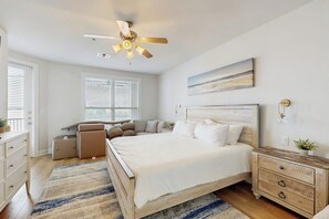 A bedroom with a bed, a desk, a ceiling fan, and a nightstand. - Stunning Lakefront Home on Lake LBJ With Private Balconies - Close to Yacht Club (Horseshoe Bay)
