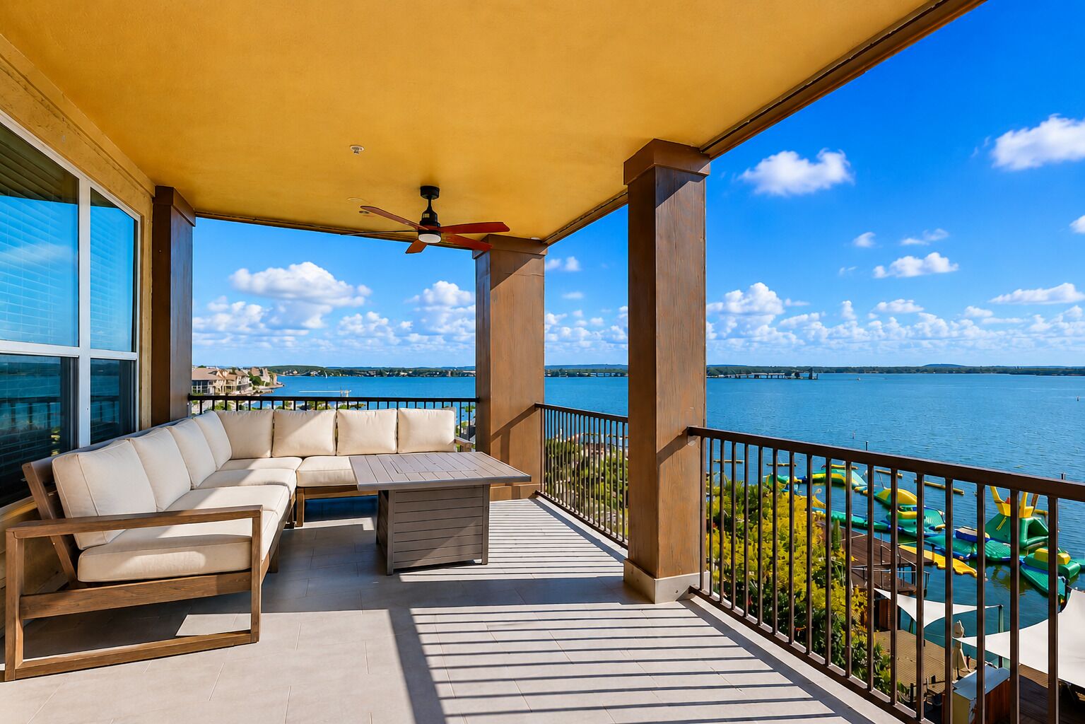 A balcony with a sofa, a table, and a view of a body of water.