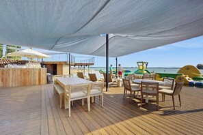 A wooden deck with outdoor seating, a bar area, and a view of the sea. - Stunning Lakefront Home on Lake LBJ With Private Balconies - Close to Yacht Club (Horseshoe Bay)