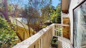 Un balcon donnant sur des arbres et un immeuble.