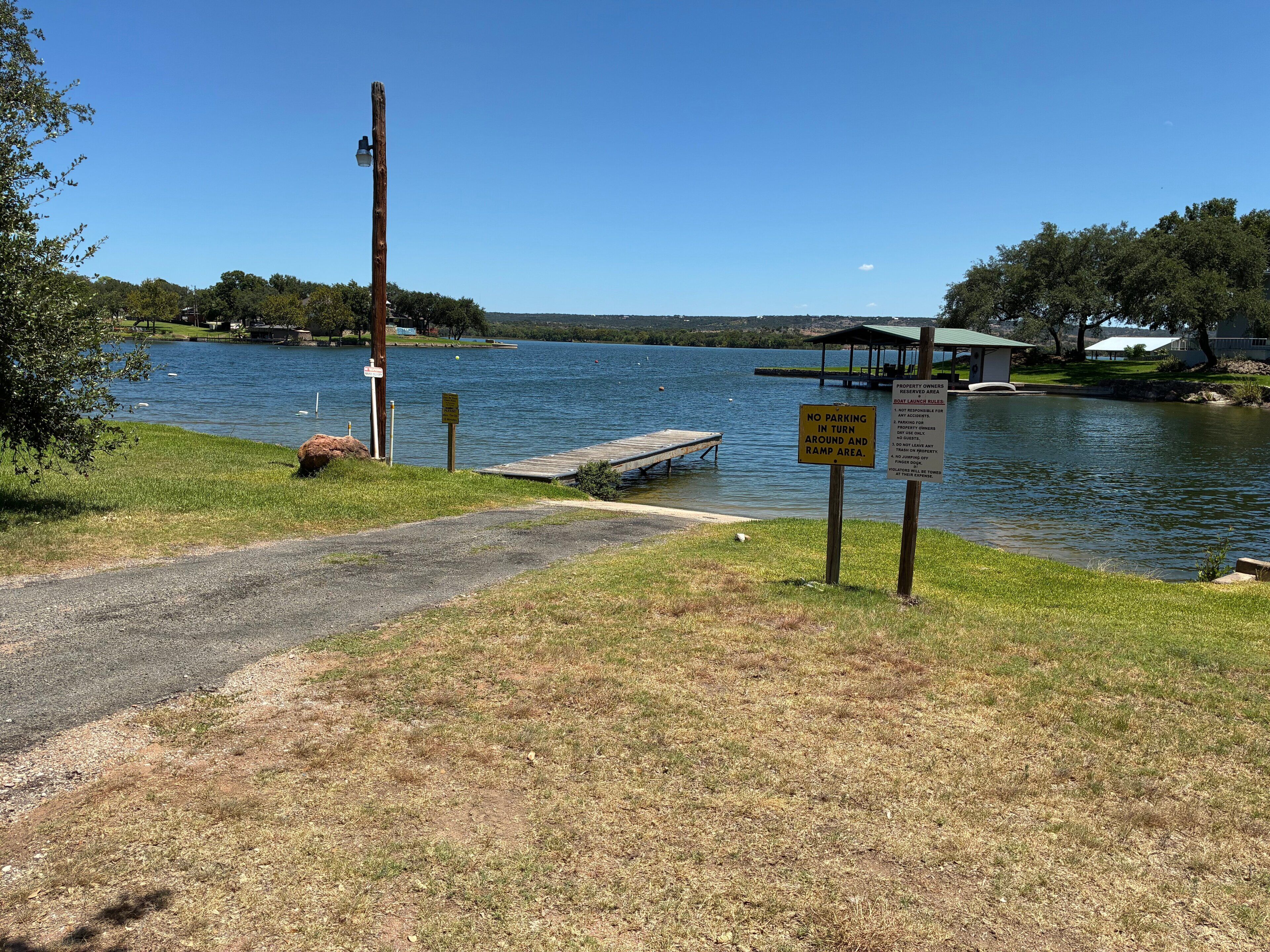 Une zone au bord du lac comprenant un quai, une rampe de mise à l’eau pour bateaux et un panneau indiquant qu’il est interdit de se garer dans la zone de retournement.