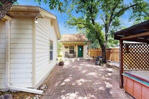 Um imóvel residencial com um alpendre de tijolos, uma garagem separada e um pequeno alvorada.