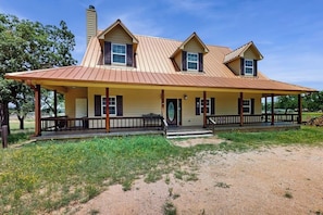 A two-story house with a covered porch, a chimney, and a front door.