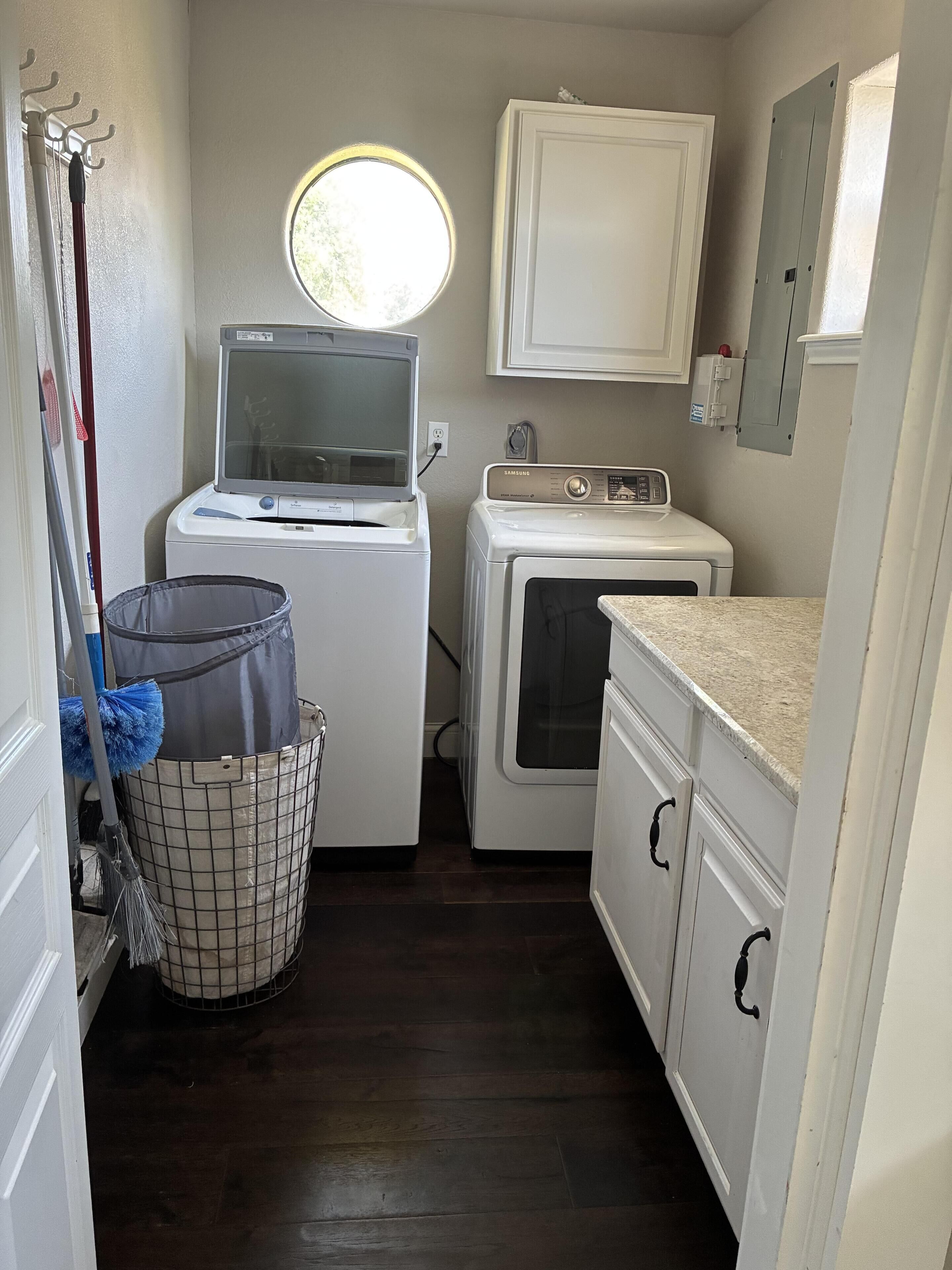 A laundry room with a washing machine, dryer, and a utility sink.