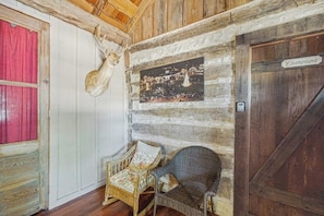 A rustic room with a deer head mounted on the wall, a wooden door labeled 'Champagne,' and two wicker chairs. - Lovely Dog-friendly Suite With Tasting Rooms Along Hwy 290 Wine Trail (Fredericksburg)