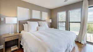 Ein Schlafzimmer mit einem großen Bett, zwei Nachttischen mit Lampen und einem Deckenventilator.