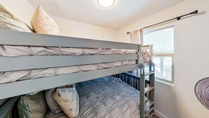 A bunk bed room with a window, a ceiling light, and a fan on the wall. - Contemporary, Dog-friendly Townhouse With Balcony, Pool & Day Docks (Horseshoe Bay)