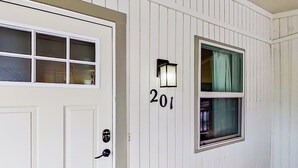 A white exterior with a door, a window, and the number '201' on the wall. - Contemporary, Dog-friendly Townhouse With Balcony, Pool & Day Docks (Horseshoe Bay)