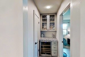 A narrow hallway with a built-in oven, a small kitchen area with cabinets, and a fan. - Contemporary, Dog-friendly Townhouse With Balcony, Pool & Day Docks (Horseshoe Bay)