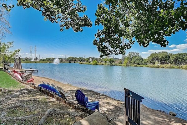 A lakeside area with a dock, lounge chairs, and a fountain. - Dog-friendly Water View Condo With Inviting Porch, AC, W/d, & Modern Charm (Horseshoe Bay)