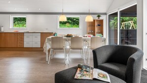 Une cuisine moderne avec un coin repas, de grandes fenêtres et un espace salon confortable.