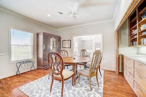 A dining area with a round table, four chairs, a ceiling fan, and a bookshelf. - Lakeside, Dog-friendly Living With Kayaks, Boat Ramp, Pool Table & Ping-pong (Kingsland)