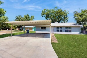 A residential house with a covered patio, a small attached garage, and a well-maintained lawn. - Dog-friendly Home w/ a Furnished Patio, Free Wifi, & Central A/C - Near Cove (Kingsland)