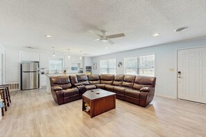 A spacious living room with a sectional sofa, a coffee table, and a kitchen in the background. - Dog-friendly Home w/ a Furnished Patio, Free Wifi, & Central A/C - Near Cove (Kingsland)