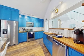 A modern kitchen with blue cabinets, stainless steel appliances, and a wooden countertop. - Lakefront Home on Water With Great Views, Boat Dock, Al Fresco Dining, and Wifi (Kingsland)