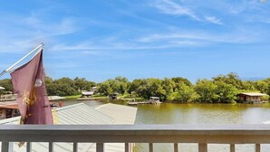 Vista para o lago com um cais, barcos e edifícios ao fundo.