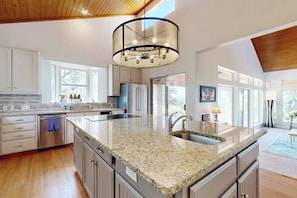 A modern kitchen with granite countertops, stainless steel appliances, and a large island. - Regal Riverfront Home With 2 Cabins - 2 Miles to Marina (Spicewood)