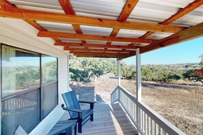 A covered outdoor area with wooden beams, a bench, and a view of a vineyard. - Tranquil Farmstead With Beautiful Views of the Country, Fire pit (Hye)