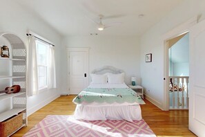 A bedroom with a bed, a ceiling fan, a window, a door, and a staircase. - Tranquil Farmstead With Beautiful Views of the Country, Fire pit (Hye)