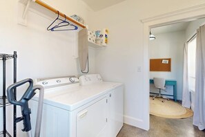 A laundry area with a washing machine, a drying rack, and a vacuum cleaner. - Tranquil Farmstead With Beautiful Views of the Country, Fire pit (Hye)