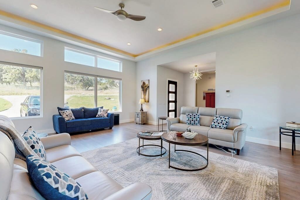 A spacious living room with two sofas, a coffee table, and a ceiling fan.